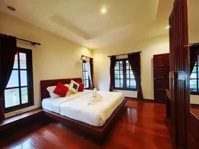 a bedroom with a bed with white sheets and red pillows at Secure 3 Bedroom Villa near beach in Kamala Beach