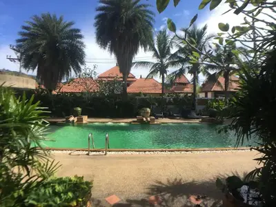 a pool in front of a house with palm trees at Secure 3 Bedroom Villa near beach in Kamala Beach