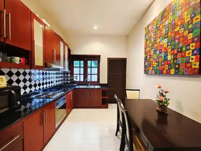 a kitchen with a table and a large painting on the wall at Secure 3 Bedroom Villa near beach in Kamala Beach