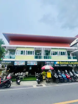 a building with motorcycles parked in front of it at Ann & John Guesthouse in Patong Beach