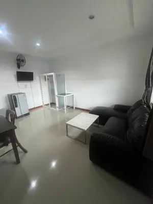 a living room with a couch and a table at Ann & John Guesthouse in Patong Beach