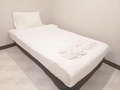 a bed with white sheets and white bowls on it at XX Mitr Inn Phuket Oldtown in Phuket Town