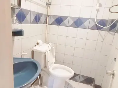 a bathroom with a toilet and a blue tub at XX Mitr Inn Phuket Oldtown in Phuket Town