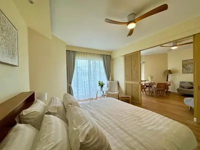 a bedroom with a large bed with a ceiling fan at Cozy 1 BR Allamanda Laguna Phuket in Laguna Phuket