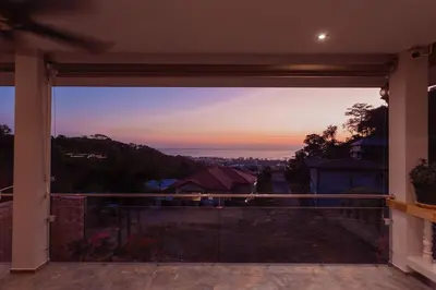 a view of the sunset from the balcony of a house at Tropical 2BR Villa Sunset & Sea View in Karon Beach