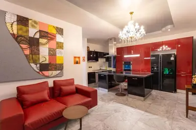 a living room with a red couch and a kitchen at Tropical 2BR Villa Sunset & Sea View in Karon Beach