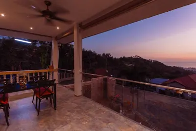 a balcony of a house with a view of the ocean at Tropical 2BR Villa Sunset & Sea View in Karon Beach