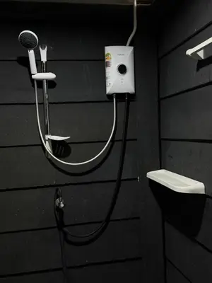 a black bathroom with a hair dryer and a microphone at Global Beach Hostel - Ao Nang in Ban Khlong Haeng