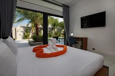 a bedroom with a bed with a towel animal on it at Andaman Paradise 3 - Luxury 4 Bedrooms Pool Villa in Rawai Beach