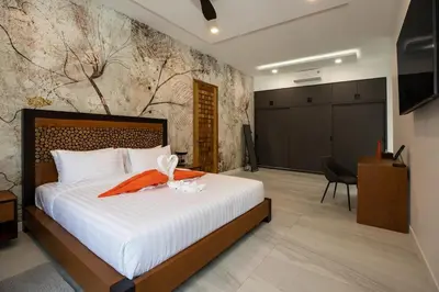 a hotel room with a bed and a television at Andaman Paradise 3 - Luxury 4 Bedrooms Pool Villa in Rawai Beach