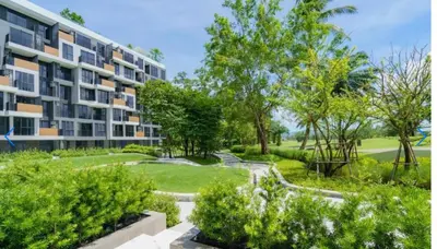 an apartment building with a garden in front of it at \u9876\u7ea7\u9ad8\u5c14\u592b\u7403\u573a\u98ce\u666f in Phuket