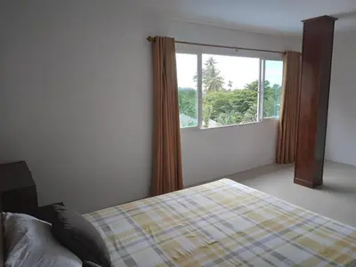 a bedroom with a bed and a large window at Hillside 3 Bedroom Vacation Home with Pool in Kamala Beach