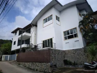a white house with a fence in front of it at Hillside 3 Bedroom Vacation Home with Pool in Kamala Beach