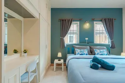 a blue bedroom with a bed and a desk at Areca Holiday Home 7, Bangtao Beach in Ban Thalat Choeng Thale