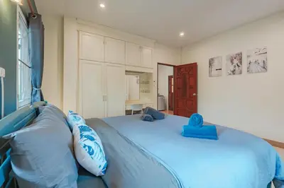 a bedroom with a blue bed with blue pillows at Areca Holiday Home 7, Bangtao Beach in Ban Thalat Choeng Thale