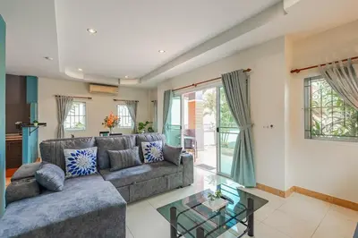 a living room with a couch and a glass table at Areca Holiday Home 7, Bangtao Beach in Ban Thalat Choeng Thale