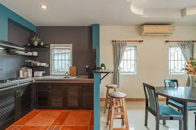 a kitchen and dining room with a table and chairs at Areca Holiday Home 7, Bangtao Beach in Ban Thalat Choeng Thale