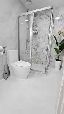 a white bathroom with a shower and a toilet at Patong Tower 2 Bedroom Sea View 8 Floor in Patong Beach