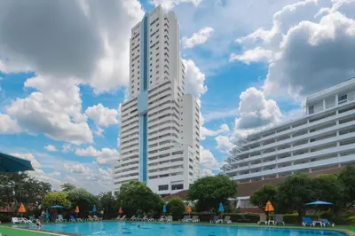 a tall white building with a pool in front of it at Patong Tower 2 Bedroom Sea View 8 Floor in Patong Beach