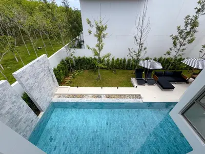 a swimming pool with two umbrellas and two chairs at Sumptuous Duplex Pool Villa 3BR in Newly Built LuxPride 4 L12 Residence in Bang Tao Beach