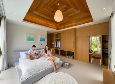 a man and a woman sitting on a bed at Sumptuous Duplex Pool Villa 3BR in Newly Built LuxPride 4 L12 Residence in Bang Tao Beach