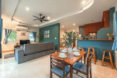 a living room with a table and a couch at Areca Holiday Home 8, Bangtao Beach in Ban Thalat Choeng Thale