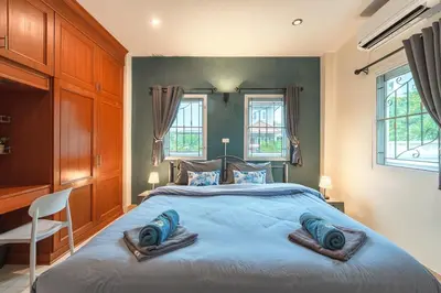 a bedroom with a large bed with two pillows on it at Areca Holiday Home 8, Bangtao Beach in Ban Thalat Choeng Thale