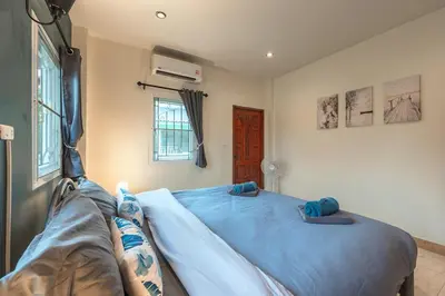 a bedroom with a large bed with blue sheets at Areca Holiday Home 8, Bangtao Beach in Ban Thalat Choeng Thale