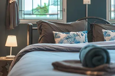 a bedroom with two beds and a lamp and a window at Areca Holiday Home 8, Bangtao Beach in Ban Thalat Choeng Thale