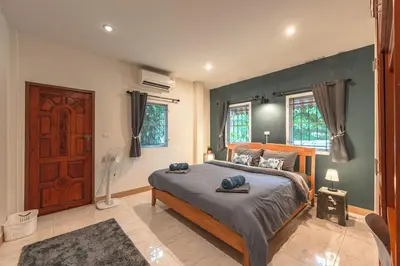 a bedroom with a large bed in a room at Areca Holiday Home 8, Bangtao Beach in Ban Thalat Choeng Thale