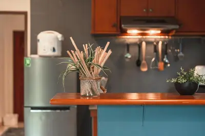 a kitchen with a counter with a refrigerator and a vase with plants at Areca Holiday Home 8, Bangtao Beach in Ban Thalat Choeng Thale