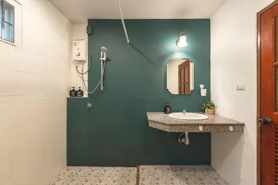 a bathroom with a sink and a green wall at Areca Holiday Home 8, Bangtao Beach in Ban Thalat Choeng Thale