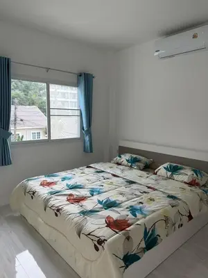 a large bed in a bedroom with a window at Karon Beach Villa in Karon Beach