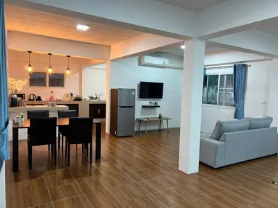 a living room and kitchen with a couch and a table at Karon Beach Villa in Karon Beach