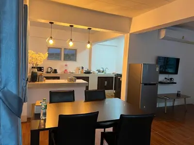 a kitchen and dining room with a table and a refrigerator at Karon Beach Villa in Karon Beach