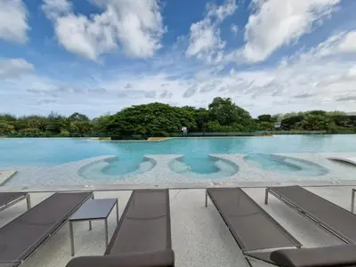 a pool of water with benches in the middle at Laguna Song in Bang Tao Beach