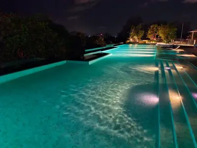 a swimming pool lit up at night at Laguna Song in Bang Tao Beach