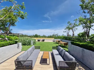 a patio with a couch and chairs and a lawn at Laguna Song in Bang Tao Beach