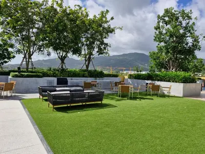 a park with chairs and tables on the grass at Laguna Song in Bang Tao Beach