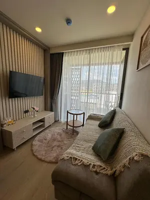 a living room with a couch and a tv in a room at The Ozone Condotel Phuket BangTao Beach Spacious 1-BR in Laguna Phuket