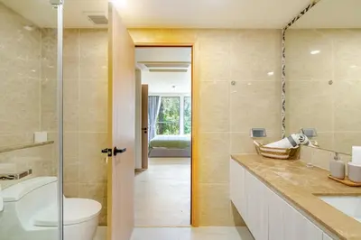 a bathroom with a toilet and a sink and a mirror at The Ozone Condotel Phuket BangTao Beach Spacious 1-BR in Laguna Phuket