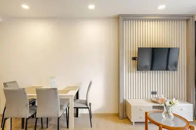 a dining room with a table and a television on a wall at The Ozone Condotel Phuket BangTao Beach Spacious 1-BR in Laguna Phuket