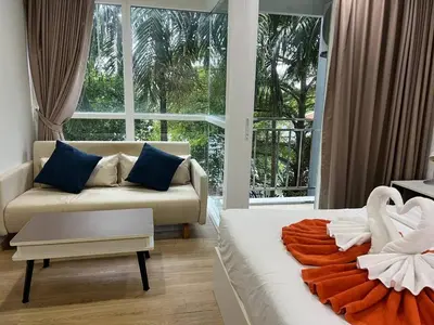 a living room with two beds and a couch at OZONE Best Studio After Renovation 2025 in Kata Beach