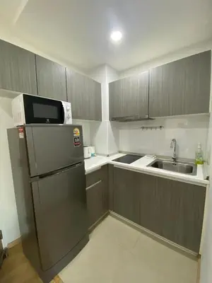 a small kitchen with a refrigerator and a sink at OZONE Best Studio After Renovation 2025 in Kata Beach