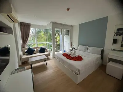 a bedroom with a large white bed and a couch at OZONE Best Studio After Renovation 2025 in Kata Beach