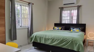 a bedroom with a bed and two windows at Best Bliss, Bangtao Beach in Ban Thalat Choeng Thale