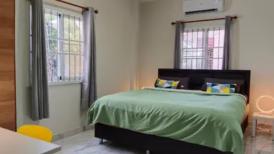 a bedroom with a bed and two windows at Best Bliss, Bangtao Beach in Ban Thalat Choeng Thale