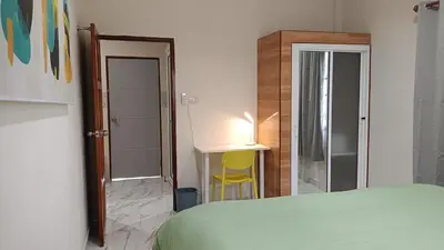 a bedroom with a bed and a desk with a lamp at Best Bliss, Bangtao Beach in Ban Thalat Choeng Thale
