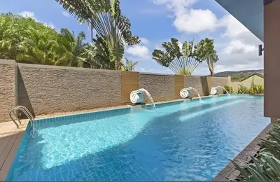 a swimming pool at a resort with palm trees at CHIC CONDO - Best mountain view near Karon beach in Karon Beach