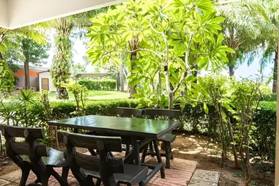 a green table and chairs with trees in the background at CHIC CONDO - Best mountain view near Karon beach in Karon Beach